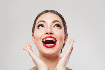 Exsited happy woman with braces on teeth, face close up