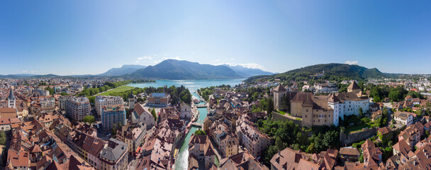 Annecy city center panoramic aerial view with the old town, castle, Thiou river and mountains surrounding the lake, beautiful summer vacation tourism destination in France, Europe - obrazy, fototapety, plakaty