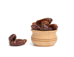 heap of dried dates in a wooden bowl and isolated on a white background