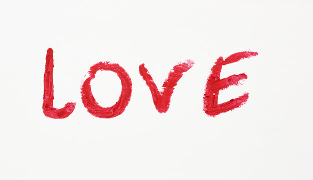 love written in red lipstick on a white paper, date concept