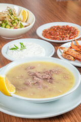 Turkish Traditional Soup with bread on white rustic wooden background, kelle, paca corbasi.