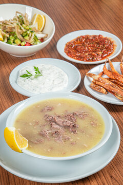 Turkish Traditional Soup with bread on white rustic wooden background, kelle, paca corbasi.