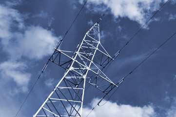 Power line mast against the blue sky.