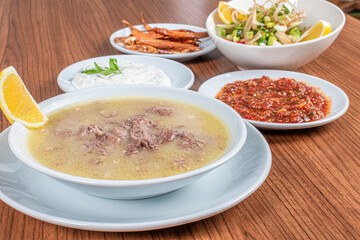 Turkish Traditional Soup with bread on white rustic wooden background, kelle, paca corbasi.