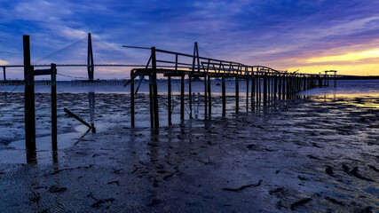 wooden pier in front of arthur ravenel bridge 