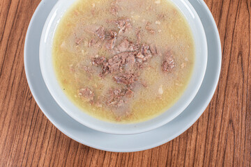 Turkish Traditional Soup with bread on white rustic wooden background, kelle, paca corbasi.