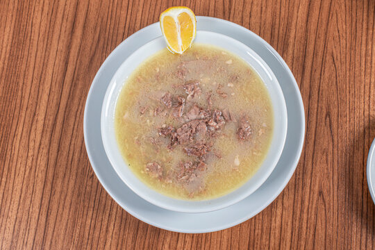 Turkish Traditional Soup with bread on white rustic wooden background, kelle, paca corbasi.