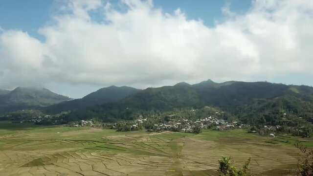A capture of Spider Web Rice Fields in Ruteng on Flores, Indonesia. The rice fields are stretching on the bottom of the valley, surrounded by hills. Small village at the foothill. Agriculture
