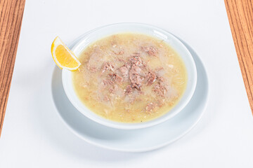 Turkish Traditional Soup with bread on white rustic wooden background, kelle, paca corbasi.