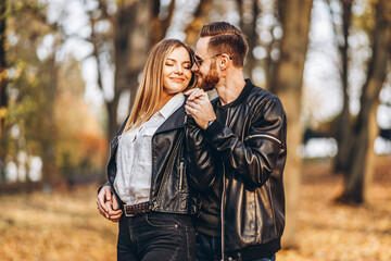 A young couple in love walking in the autumn park on a sunny day