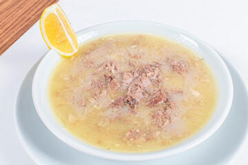 Turkish Traditional Soup with bread on white rustic wooden background, kelle, paca corbasi.