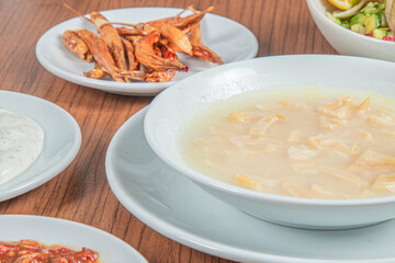 Turkish Traditional Soup with bread on white rustic wooden background, iskembe corbasi.