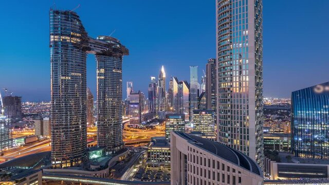 Aerial view of new and tall buildings with busy roads timelapse. Transition from day to night in Dubai Downtown from above, Dubai, United Arab Emirates