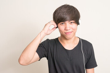Portrait of young Filipino man listening to music