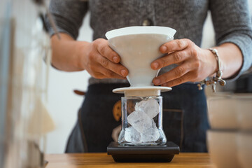 Woman barista preparing a V60 filter specialty coffee in a cafe