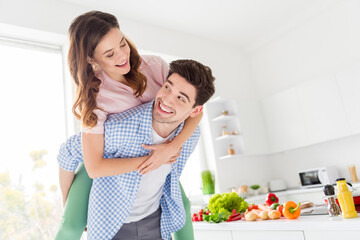 Portrait of tender gentle passionate two people couple vegan man hug piggyback woman enjoy weekend dish meal dinner preparation have rest relax leisure in kitchen house indoors