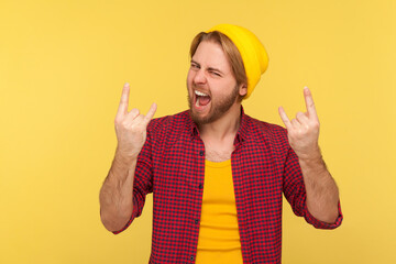 Yeah, this is crazy! Delighted happy hipster bearded guy in beanie hat and checkered shirt shouting...
