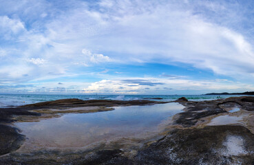 Rocky coast with water reflections and blue sky