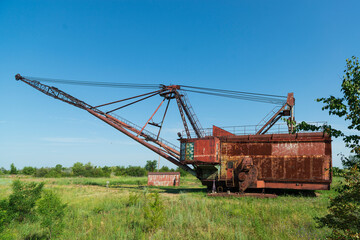 Fototapeta na wymiar Old rusted walking excavator near abandoned coal mine
