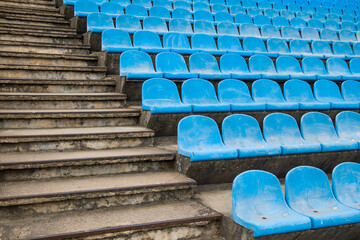 Fototapeta premium an abandoned sports stadium. old blue seats on the grandstand