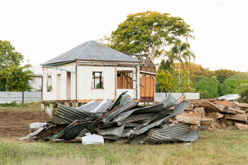 Old house being demolished with piles of corrugated iron sheeting and rubble