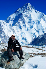 A man in front of the Chogori snow peak. K2 mountain. Winter tourism in Karakorum, Pakistan. Vertical