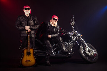 Obraz na płótnie Canvas Full length photo of old two cool bikers man lady sit chopper rock festival play guitar famous popular metal band meeting wear trendy rocker leather outfit isolated black color background