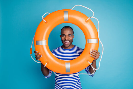 Portrait Of His He Nice Attractive Handsome Cheerful Cheery Glad Guy Rescuer Sailor Holding In Hands Rubber Lifesaver Isolated Over Bright Vivid Shine Vibrant Blue Color Background