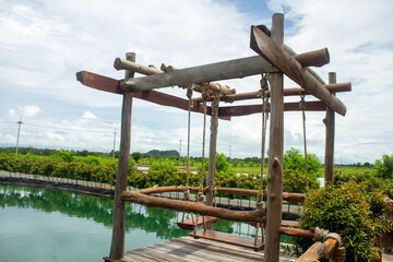 Green water views, beautiful flowers surrounded, and blur wooden swings, perfect for relaxing during holidays.