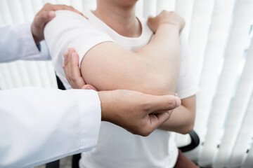 Obraz na płótnie Canvas male physiotherapists provide assistance to male patients with elbow injuries to examine patients in rehabilitation centers. Rehabilitation physiotherapy concept
