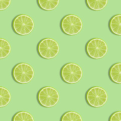 Colorful fruit seamless pattern of fresh lime slices on green background. Trendy sunlight Summer pattern. Minimal summer concept. flat lay food texture