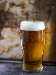 A glass of lager a pint close up on a concrete table