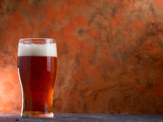 A glass of beer red ale on a concrete background - obrazy, fototapety, plakaty