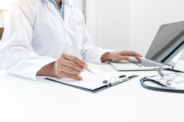 The female doctor sat and checked the patient's history and used a laptop to record patient information at the hospital. Medical concepts and interests