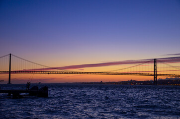Fototapeta na wymiar The 25th of April suspension bridge over the Tagus river, at sunset, in Lisbon, Portugal.