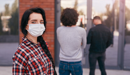 Woman in mask keeping social distance in queue