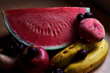 Still life of fruit, with watermelon, bananas, cherries, apples and peaches