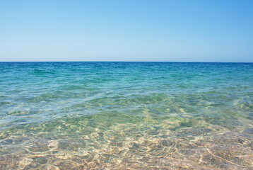 Fototapeta na wymiar Transparent clear sea with a sandy shore. The shore of the Black Sea. Holidays on the shore