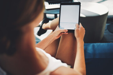 Closeup image of woman holding digital tablet with blank copy space screen for your advertising text message or promotional content, young female thinking what to write in text message on touch pad