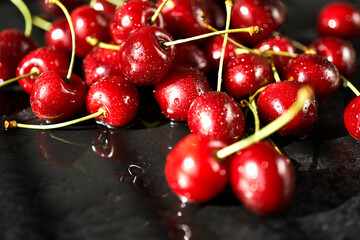 juicy red cherries on a black stone table