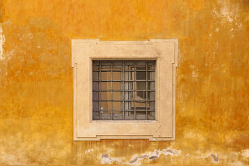Yellow wall with window with bars.