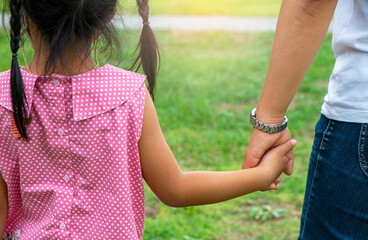 Little daughter holding mother hand