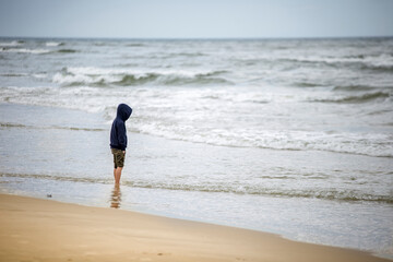 Chłopak na brzegu morza - obrazy, fototapety, plakaty