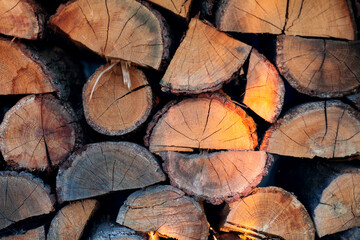 Naklejka premium Firewood in logs, large and small chopped branches. for the bath and fireplace. Natural fuel for the fireplace and heating the house, barbecue, cooking barbecue and meat on the grill