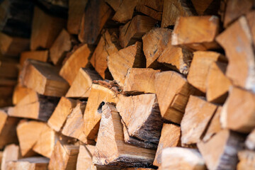 Firewood in logs, large and small chopped branches. Chipped firewood is in storage. Finished firewood for the bath and fireplace. Background of firewood. 