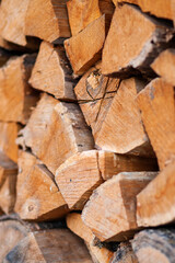 Firewood in logs, large and small chopped branches. Chipped firewood is in storage. Finished firewood for the bath and fireplace. Background of firewood. Natural fuel for the fireplace 