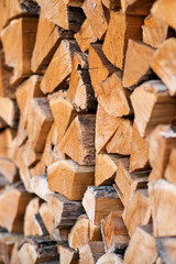 Firewood in logs, large and small chopped branches. Chipped firewood is in storage. Finished firewood for the bath and fireplace. Background of firewood. Natural fuel for the fireplace 