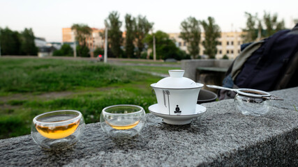 Chinese traditional tea drinking in the city. Tea saws, sieves and gaiwan in the city landscape.
