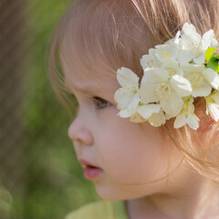 Obraz na płótnie Canvas Portrait of a little cute girl with a jasmine flower in her hair