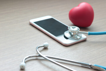 Doctor online concept, red heart with stethoscope and  smartphone for online consultation with patient, online medical communication on virtual interface, virtual hospital